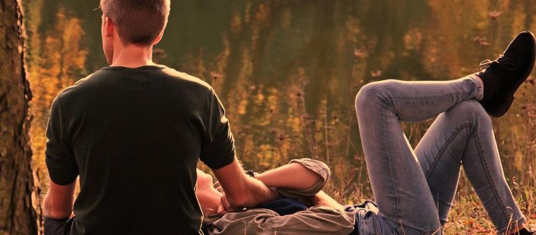 Couple de jeunes adultes au bord de l'eau